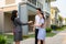 Asian happy smile young couple take keys new big house from real estate agent or realtor in front of their house after signing