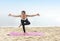 Asian healthy woman practicing yoga on the carpet in beach