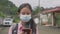 Asian high school girl with backpack in face mask watching social media video from mobile smartphone.