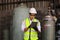 Asian industrial worker using digital tablet to check the coolant system in the factory while standing before liquid nitrogen