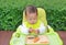 Asian infant baby boy eating by Baby Led Weaning BLW. Finger foods concept