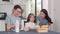 Asian Japanese family has breakfast at home. Asian mom, dad, and daughter feeling happy talking together eat bread, corn flakes