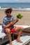 Asian, Japanese teenager playing the Ukulele on a beach in Chiba Japan