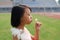 Asian kid blowing dandelions in the field