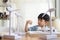 Asian kid boy playing wind turbine model in home office with home model