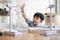 Asian kid boy playing wind turbine model in home office with home model