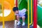 Asian kid playing slide at the playground under the sunlight in summer, Happy kid in kindergarten