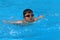 Asian kid swims in swimming pool - butterfly style take deep breath