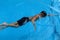 Asian kid swims in swimming pool - front crawl style take breath