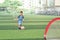 Asian  kindergarten boy, football player in soccer uniform is playing football at Training Session, Soccer Drills for Kids concept