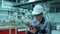 Asian Korean professional male engineer in hard hat using mobile phone smartphone