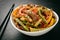 Asian (korean) salad with beef, vegetables and sesame seeds on black board.