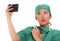 Asian Korean woman as successful taking selfie on hand phone - young beautiful and happy medicine doctor or hospital nurse taking