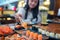 Asian lady eat a Salmon fish sashimi and Sushi in Japanese restaurant