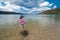 An asian lady in a high waist bikini admires the scenery at the beach. Adventure and weekend getaway theme