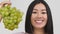 Asian Lady Holding Bunch Of Grapes Near Face, White Background