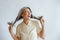 Asian lady holds long hoary hair laughing on light grey background