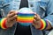 Asian lady wearing blue jean jacket or denim shirt and holding rainbow color flag with globe, symbol of LGBT pride month celebrate