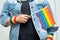 Asian lady wearing blue jean jacket or denim shirt and holding rainbow color flag, symbol of LGBT pride month celebrate annual in