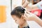 Asian lady weaving braids hair for Child little