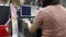 Asian lady working editing image photographs using a desktop computer application in a photo printing shop.