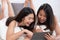 Asian lesbian couple lying down on bed using tablet browsing internet in morning at cozy home