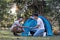 Asian LGBTQ couple camping together Set up a tent on the grass During the weekend vacation