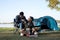 Asian LGBTQ couple drinking coffee in a romantic camping tent. LGBTQ couple drinking coffee in a camping tent, enjoying