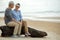 Asian Lifestyle elderly couple romantic lover hug and sitting on the beach happy in love romantic and relax time.