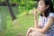 Asian little child girl feeling stressed,female worried bites finger nails in outdoor park,girl patient with nervous expression,