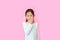 Asian little child girl with finger in nose isolated on pink background. Kid picking at her nostril