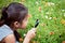 Asian little child girl looking through a magnifying glass