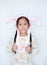 Asian little child girl wearing headband bunny ears on white background