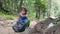 Asian little children is picking up garbage and plastic bottle in black bags on the edge of a public river.