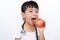 Asian Little Chinese Girl Dressed up as Doctor with a Stethoscope Eating an apple