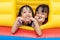 Asian Little Chinese sisters playing at inflatable castle