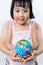 Asian Little Girl and Adult Holding a World Globe in Hands