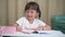 Asian little girl doing school home work Drawing and painting at home