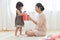 Asian Little girl and her Mother unwrapping a red gift box together.