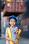 Asian little girl  holding walkie- talkie at Container cargo site. Business heir concept.