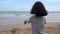 Asian little girl playing on the beach with nature sea wave coast for summer vacation concept