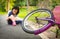 Asian little girl sitting down on the road with a slight sore leg pain due to a falling bicycle accident,the bike fall in front of