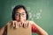 Asian  little girl smiles and holds a book in her hand and is using her thoughts in the classroom, Education  lifestyle concept