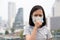 Asian little girl suffer from cough with face mask protection,cute child wearing face mask because of air pollution in the city