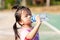 Asian little girls drink some water from plastic bottles. Child sweat from exercise in hot weather. Children is thirsty.