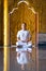 Asian long hair man relaxes meditation with all white costume sit in front of Buddist`s gold wallpaper in the Temple, Thailand