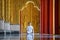 Asian long hair man relaxes meditation with all white costume sit in front of Buddist`s gold wallpaper in the Temple, Thailand