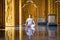 Asian long hair man relaxes meditation with all white costume sit in front of Buddist`s gold wallpaper in the Temple, Thailand
