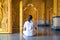 Asian long hair man relaxes meditation with all white costume sit in front of Buddist`s gold wallpaper in the Temple, Thailand