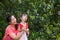 Asian lovely girl and her mother blowing soap bubbles. Family in